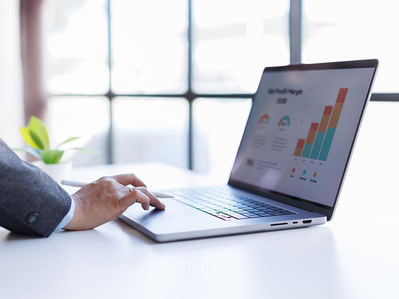 Hand using keyboard with monitor on